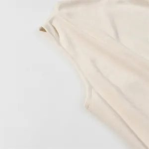 Detail view of cream sleeveless knitted dress showing high-quality fine knit texture