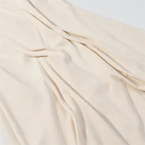 Detailed close-up showing the soft cream knit fabric texture and elegant drapes.