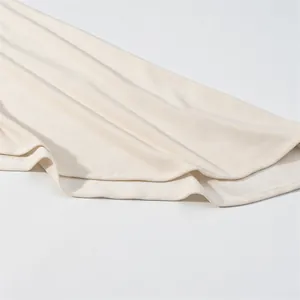 Macro view of cream knitted fabric texture and hem on this asymmetric long dress