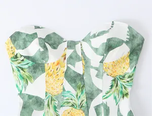 Detailed macro view showing tropical pineapple print and sweetheart neckline of corset dress