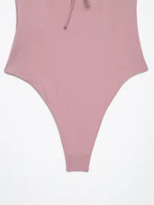 Close-up of pink halter neck bodysuit showing high-cut design and smooth fabric texture