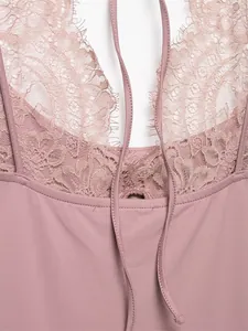 Close-up detail of the dusty pink lace trim and halter neck ties on this bodysuit.