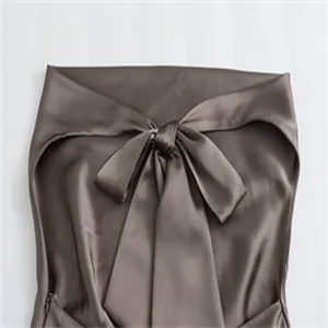 Detailansicht des eleganten Schleifenausschnitts an einem braunen Neckholder-Top aus Satin