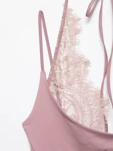 Detailed macro view of a dusty rose bodysuit featuring delicate floral eyelash lace trim