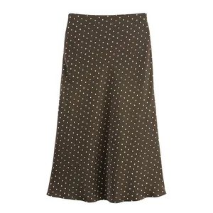 Macro view of silky satin texture and white polka dot pattern on brown midi skirt