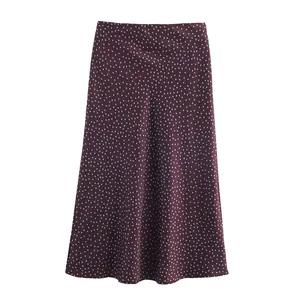 Detailed view of the smooth satin fabric and white polka dot print on this plum midi skirt