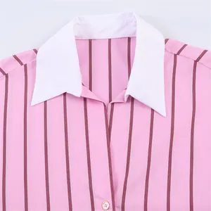 Close-up of pink striped shirt featuring a contrasting white collar and gold button