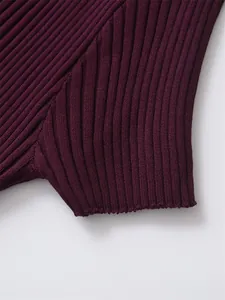 Gros plan d'un tissu en maille côtelée bordeaux montrant une texture fine verticale.