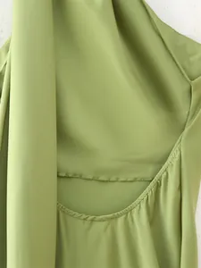 Close-up of green halter neck dress showing back cut-out and smooth fabric texture