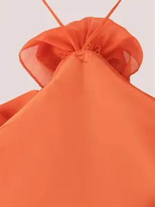 Vue rapprochée détaillée du décor floral 3D sur une robe orange particulièrement vive.