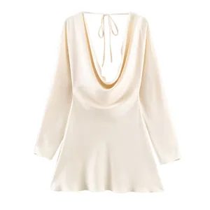 Detail view of elegant cream satin long sleeve dress with cowl neck and open back