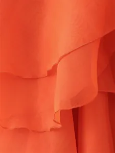 Gros plan détaillé des volants superposés orange vif sur une robe d'été en mousseline
