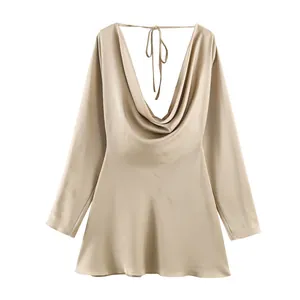 Close-up of elegant champagne silk satin dress featuring a sexy draped cowl back