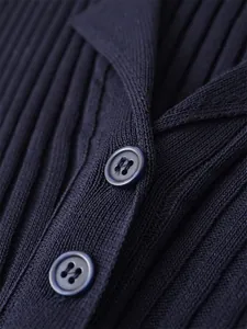 Gros plan de haute qualité sur les boutons et la texture côtelée d'une robe en tricot bleu marine