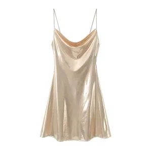 Detail shot of the shiny gold metallic fabric and cowl neck design of the dress