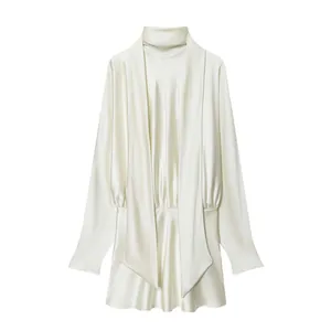 Detail view of white satin mini dress featuring high neck and elegant draped front design.