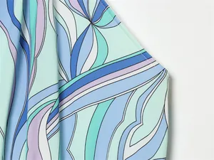 Detailed close-up of the abstract wavy geometric print and fine stitching on a summer halter dress