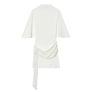Primer plano de un minivestido blanco con elegantes adornos de lentejuelas y mangas de campana.