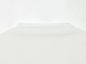 Primer plano del suave tejido blanco de alta calidad y las costuras de un vestido de verano.