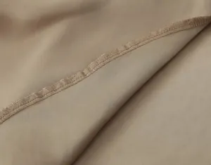 Close-up macro detail showing the neat stitching and smooth metallic fabric of the camisole dress