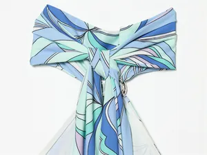Close-up of the stylish halter neck knot and abstract swirl print on blue summer dress