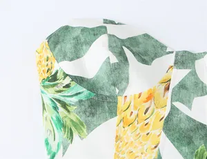 Close-up macro detail of vibrant tropical pineapple print on a sexy summer bustier dress