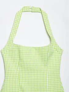 Vista dettagliata del vestito halter a quadretti verde e bianco con chiusura bottoni