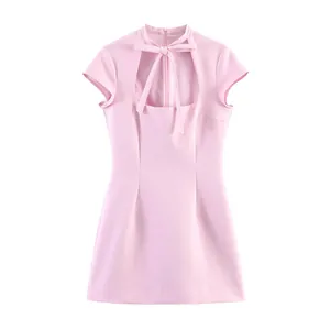 Fashionable light pink mini dress featuring a front cutout and a delicate bow tie