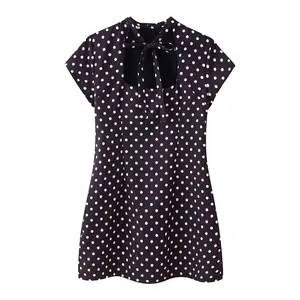 Close-up of polka dot mini dress featuring a cutout neckline and bow tie detail