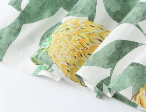 Macro view of the pineapple and leaf print on a vibrant summer bustier dress.