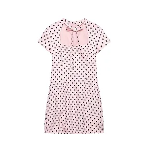 Detail view of pink polka dot dress featuring a cutout back with a decorative bow tie.