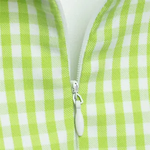 Dettaglio della cerniera invisibile su abito estivo a quadretti vichy verde e bianco.