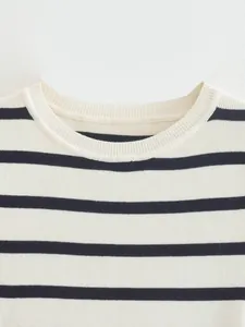 Detalle del cuello redondo acanalado de un crop top de punto a rayas azul y blanco.