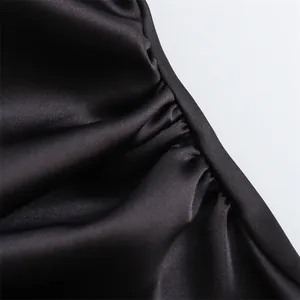 Close-up detail van zwarte satijnen stof met elegante gerimpelde textuur jurk