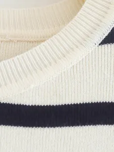 Detalle del cuello acanalado de una camiseta de punto a rayas crema y azul marino