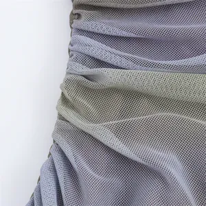 Close-up detail of ruched mesh fabric on a printed summer midi dress