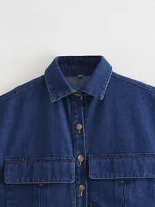 Close-up of a blue denim vest featuring a collar and heart-embossed buttons.