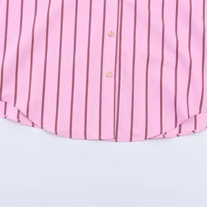 Detailed view of the pink and burgundy striped shirt hem with round golden buttons