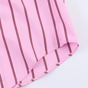 Macro view of the curved hem and fine stitching on a pink and maroon striped shirt