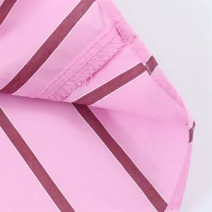 Macro view showing the high-quality stitching and pink striped fabric of the shirt.