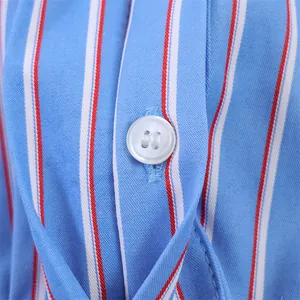 Primer plano de camisa de popelina a rayas azules y blancas con detalle de botón blanco