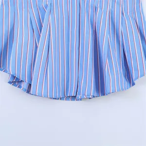 Detalle del dobladillo plisado de una camisa de popelina de algodón a rayas azules y blancas