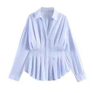 Vista detallada de una camisa de popelina azul claro con cintura plisada y manga larga