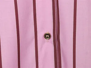 Close-up detail of a pink striped shirt featuring a golden button and fabric texture.