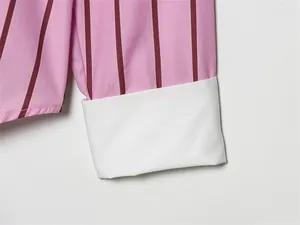 Macro view of a stylish pink striped shirt sleeve featuring a crisp white contrast cuff detail