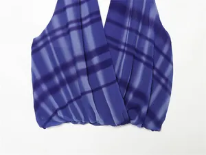 Close-up detail showing the blue plaid printed chiffon fabric texture of a summer halter neck top