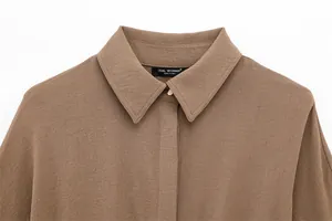 Close-up of brown long-sleeve shirt collar showing fine fabric texture and brand label