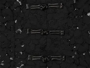 Makro-Detail des schwarzen Spitzenstoffs mit traditionellen Satin-Posamentenverschlüssen.