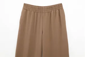 Close-up of brown casual trousers featuring an elasticated waistband and textured fabric.