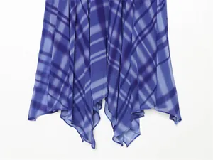 Close-up detail of a blue plaid chiffon top featuring an irregular asymmetric flared hem.